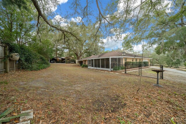 view of yard with fence and a sunroom