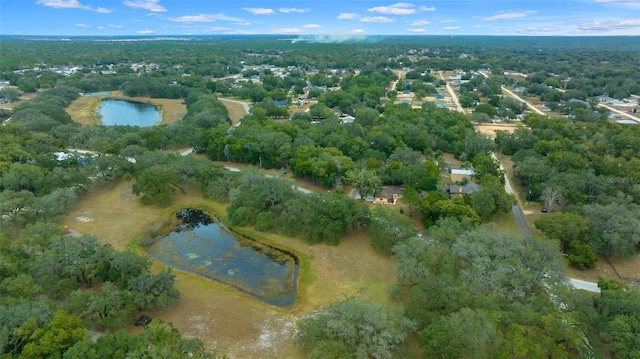 birds eye view of property featuring a water view and a wooded view