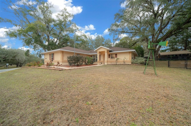 ranch-style house featuring fence, a front lawn, and stucco siding