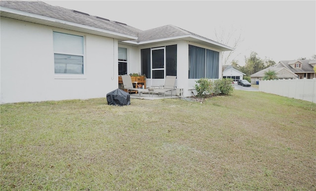 rear view of house with a patio, a sunroom, and a lawn