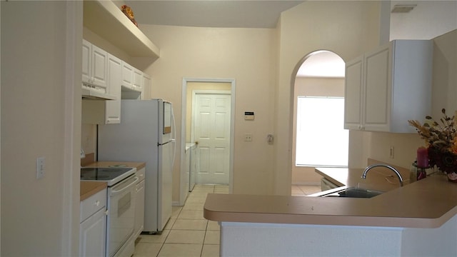 kitchen with white appliances, light tile patterned floors, sink, and white cabinets