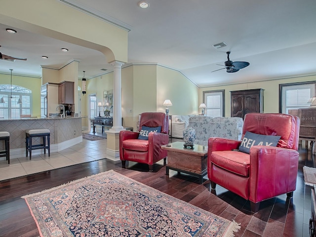 living room featuring ceiling fan, wood-type flooring, plenty of natural light, and ornate columns