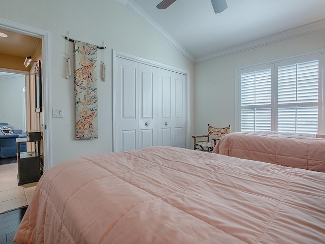 tiled bedroom with ceiling fan, a closet, lofted ceiling, and ornamental molding