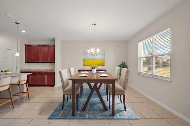 tiled dining area featuring an inviting chandelier