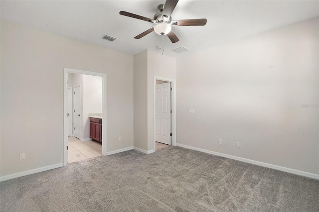 unfurnished bedroom with light carpet, ceiling fan, and ensuite bathroom