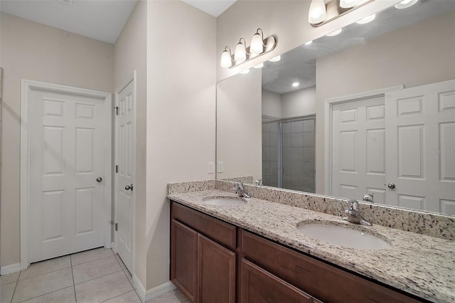 bathroom featuring a shower with door, vanity, and tile patterned floors