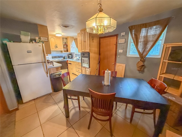 dining room with light tile patterned flooring and a chandelier