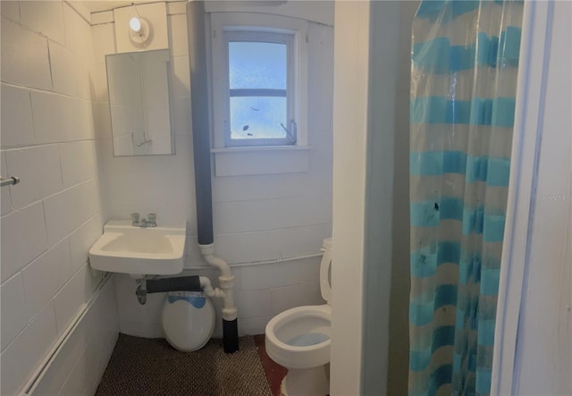 bathroom with sink, toilet, and curtained shower