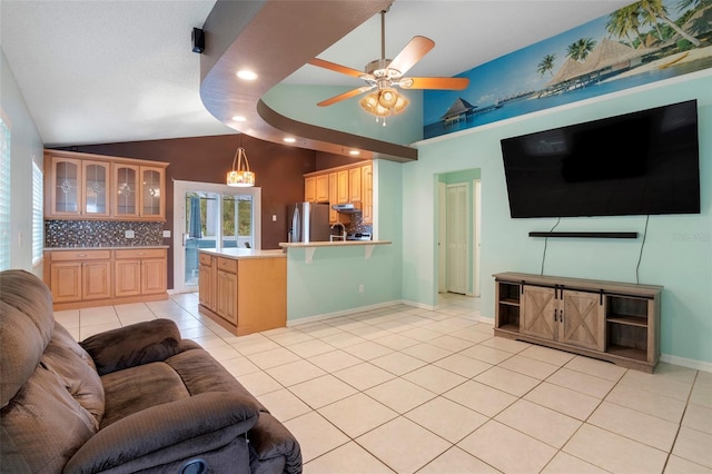 living room with vaulted ceiling, ceiling fan, and light tile patterned floors