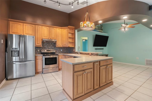 kitchen featuring ceiling fan, light tile patterned floors, decorative backsplash, hanging light fixtures, and appliances with stainless steel finishes