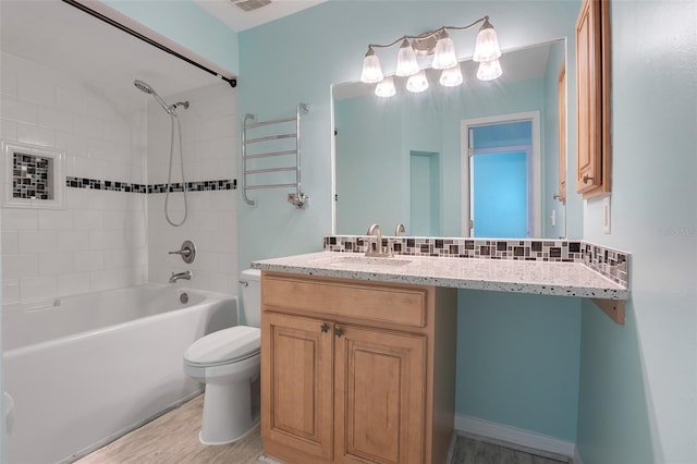 full bathroom featuring tasteful backsplash, hardwood / wood-style flooring, toilet, shower / bathing tub combination, and vanity