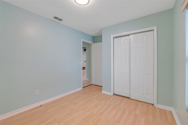 unfurnished bedroom with light hardwood / wood-style floors and a closet