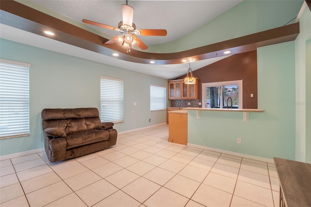 kitchen with light tile patterned floors, tasteful backsplash, hanging light fixtures, and kitchen peninsula