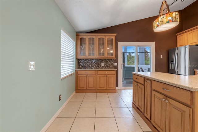 kitchen featuring lofted ceiling, light tile patterned floors, decorative backsplash, hanging light fixtures, and stainless steel refrigerator with ice dispenser