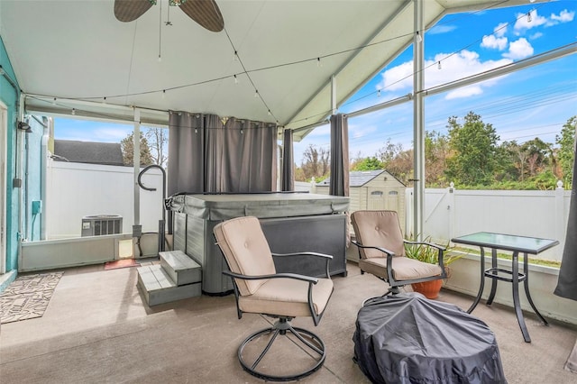 sunroom / solarium with ceiling fan, a jacuzzi, and lofted ceiling