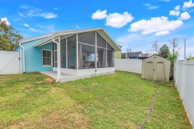 rear view of house featuring a sunroom, a patio, a lawn, and a shed