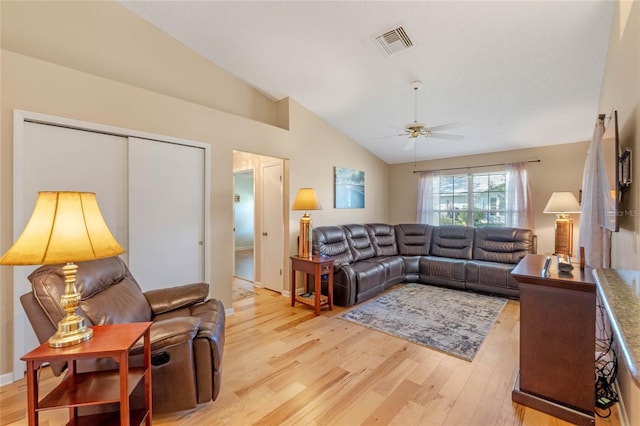 living room with ceiling fan, light hardwood / wood-style flooring, and vaulted ceiling