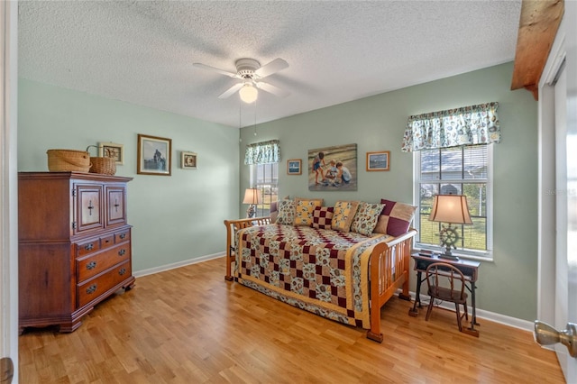 bedroom featuring ceiling fan, a textured ceiling, and light hardwood / wood-style flooring