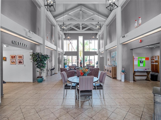 dining space with light tile patterned floors, beamed ceiling, and a high ceiling