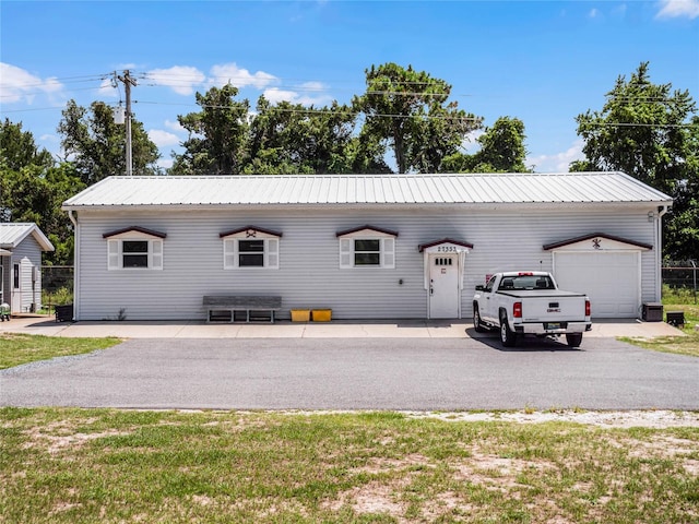 ranch-style home with a front lawn, an outdoor structure, and a garage