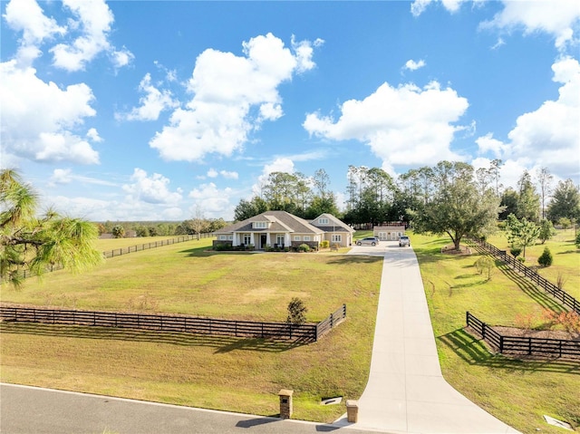 view of property's community with a rural view and a lawn