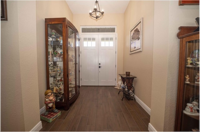 entryway with dark hardwood / wood-style flooring and an inviting chandelier