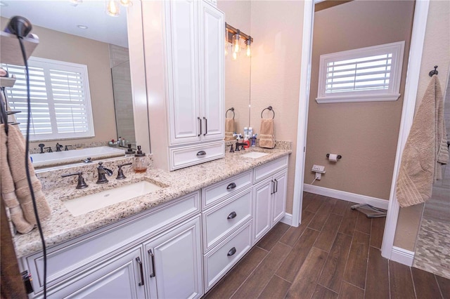 bathroom with vanity, a washtub, and plenty of natural light