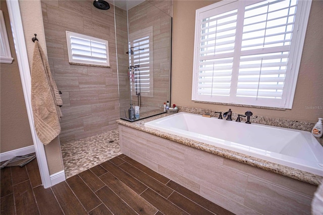 bathroom featuring a wealth of natural light and separate shower and tub