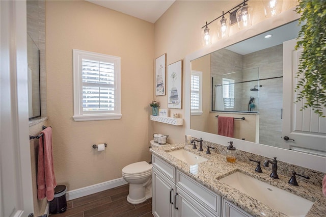 bathroom featuring toilet, tiled shower, and vanity