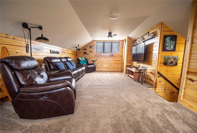 home theater with lofted ceiling, wooden walls, a textured ceiling, and carpet flooring