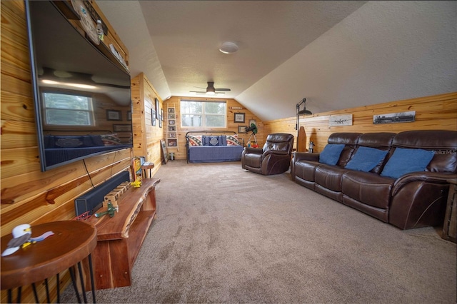 carpeted cinema featuring lofted ceiling, wooden walls, and ceiling fan