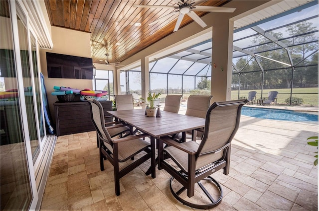 view of patio with ceiling fan and glass enclosure