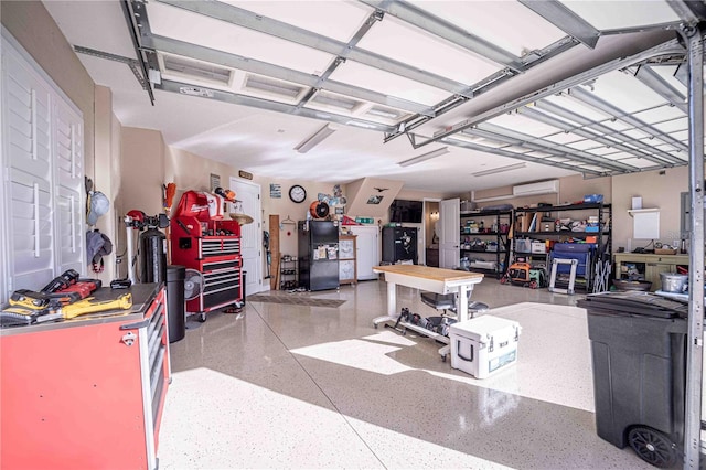 garage with washer / dryer, black refrigerator, and a workshop area