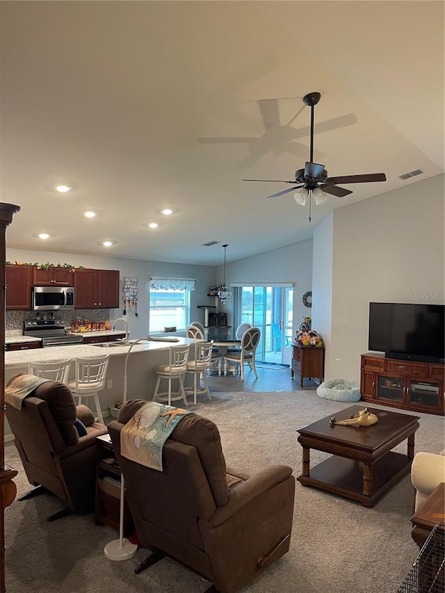 living room with ceiling fan, lofted ceiling, and carpet floors