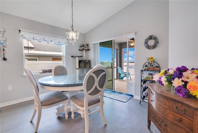 dining room with vaulted ceiling, a notable chandelier, and hardwood / wood-style floors