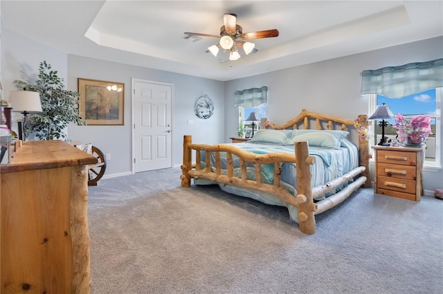 bedroom featuring ceiling fan, carpet, and a raised ceiling