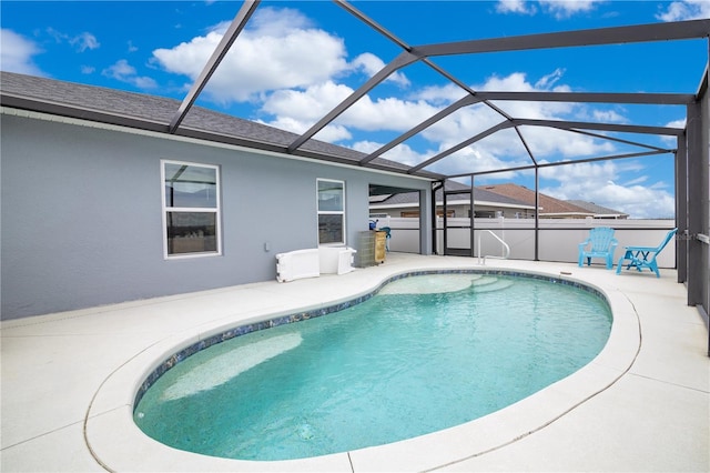 view of pool featuring glass enclosure and a patio area