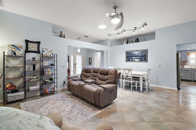 tiled living room featuring ceiling fan and french doors