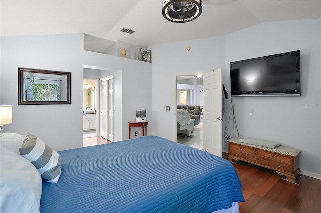 bedroom with ensuite bathroom, dark hardwood / wood-style flooring, and vaulted ceiling