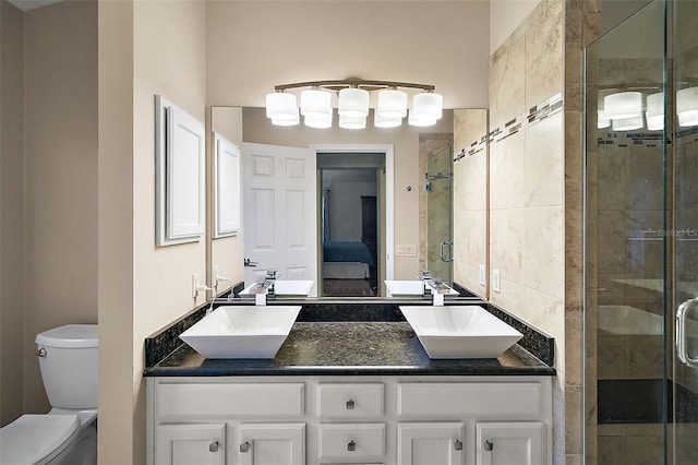 bathroom featuring toilet, a shower with door, and vanity