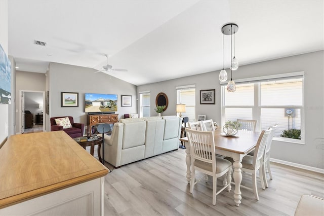 dining area featuring ceiling fan, light hardwood / wood-style flooring, and vaulted ceiling