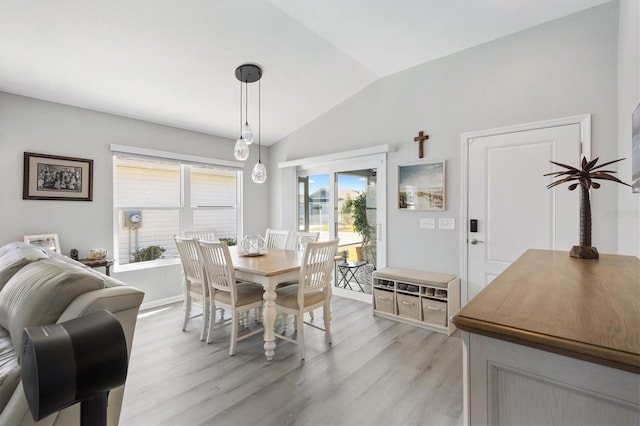 dining area with lofted ceiling and light hardwood / wood-style flooring