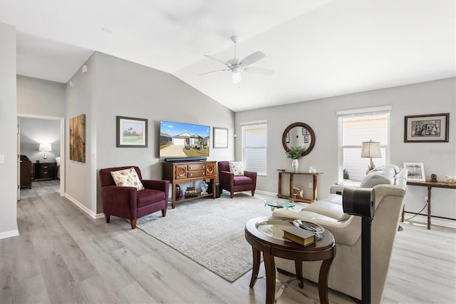 living room featuring ceiling fan, vaulted ceiling, and light wood-type flooring