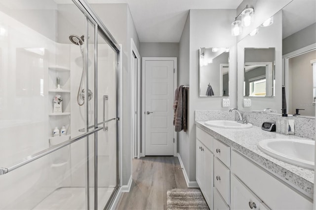 bathroom with vanity, a shower with door, and hardwood / wood-style flooring