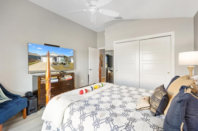 bedroom with lofted ceiling, a closet, light hardwood / wood-style floors, and ceiling fan