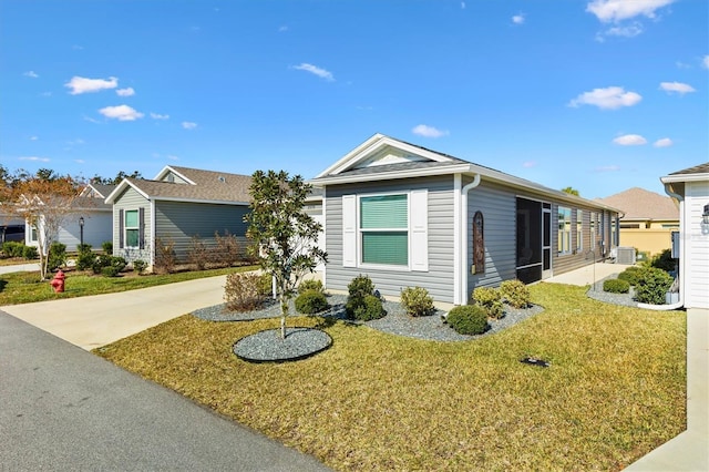 ranch-style house with a front yard and central AC