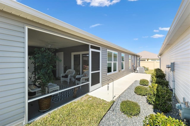 exterior space featuring a patio area, a sunroom, and central air condition unit