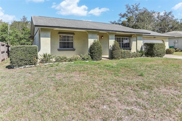 ranch-style house featuring a garage and a front lawn