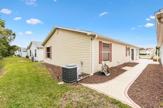 view of property exterior featuring a lawn and cooling unit