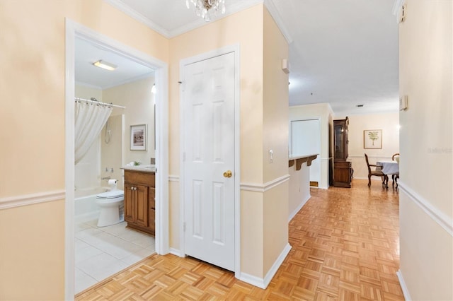 corridor with light parquet floors and ornamental molding